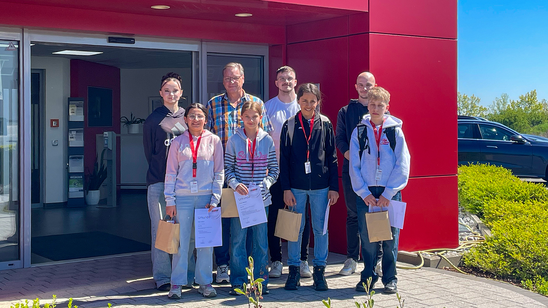 Abschied nach getaner Arbeit . Vorne v.l.n.r.: Najad A., Frieda M., Elian B. und Nicolas K. 
Hinten v.l.n.r.: Lijane P., CEO Frank Benner sowie die Betreuer Keanu Arnold und Daniel Eckstein.